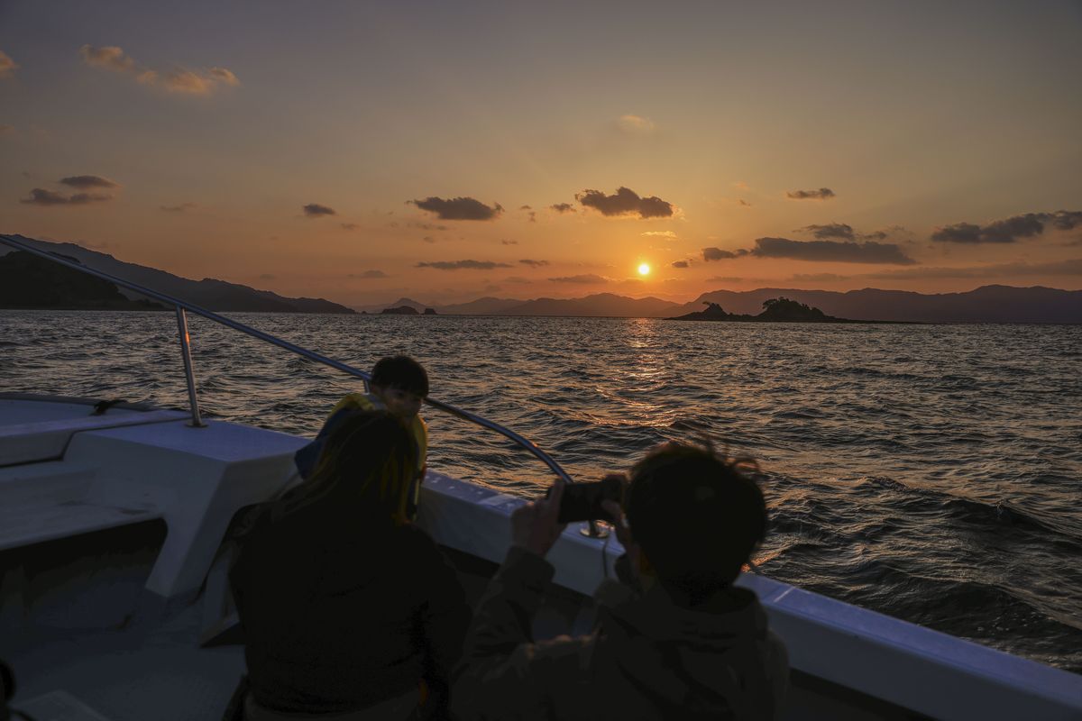 船首から見る夕日と島影