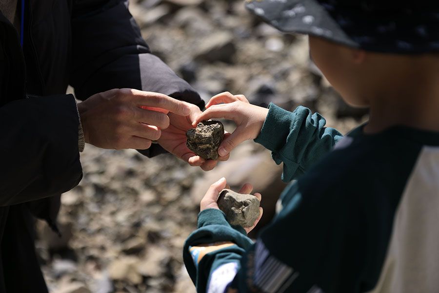 採集場で、見つけた化石をガイドと確かめる子ども